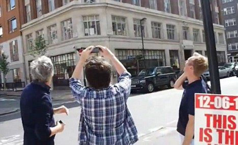 一位男子跑向街边并拿出相机进行拍摄，此时那里已经有几位路人驻足观看